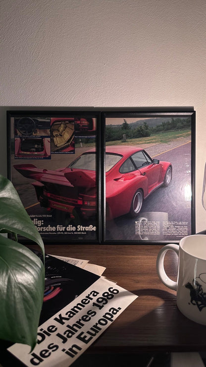 Gerahmte Oldtimer-Werbung des Porsche 935 Street, stilvoll auf einem Tisch präsentiert, umgeben von Vintage-Magazinen und einer Tasse. Perfektes Ambiente, das die unverwechselbare Sportlichkeit des legendären Porsche-Modells zur Geltung bringt.