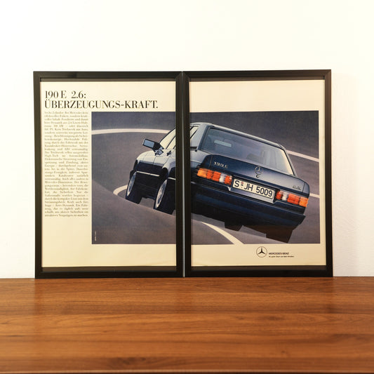 Original vintage Mercedes-Benz 190 E 2.6 advertisement framed in black aluminum. Two-piece wall art set showing the rear view of a dark blue Mercedes 190E cornering fast with the German headline 'Überzeugungs-Kraft'.