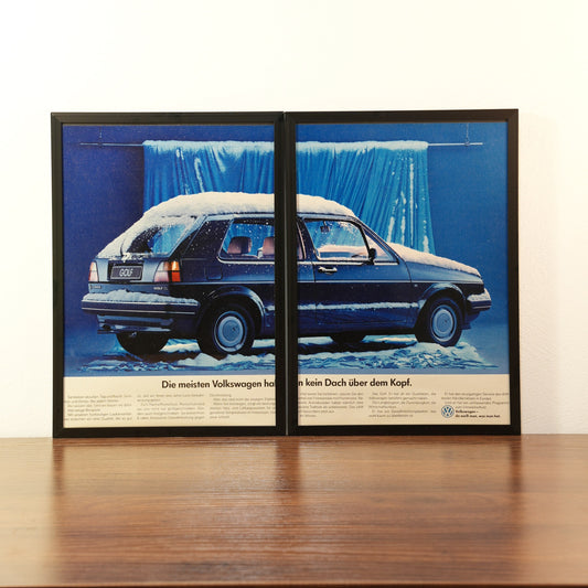 Original vintage Volkswagen Golf 2 advertisement framed in black aluminum. Two-piece diptych wall art set showing a dark blue VW Golf parked in snow with the German slogan 'Die meisten Volkswagen haben kein Dach über dem Kopf'