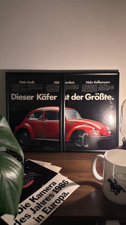 Gerahmte Oldtimer-Werbung des VW 1302 Käfer, stilvoll auf einem Tisch präsentiert, umgeben von Vintage-Magazinen und einer Tasse. Perfektes Ambiente, das die charmante Ikone der 70er Jahre zur Geltung bringt.